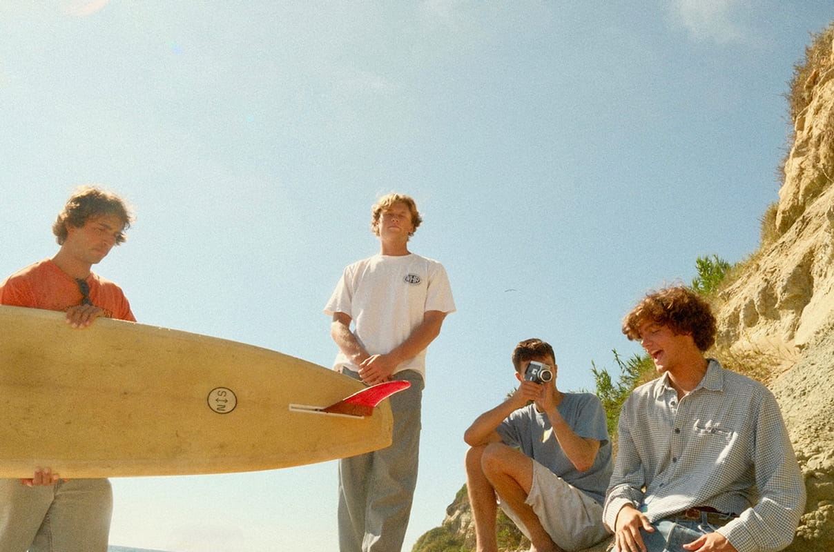 The band on the beach with a surfboard